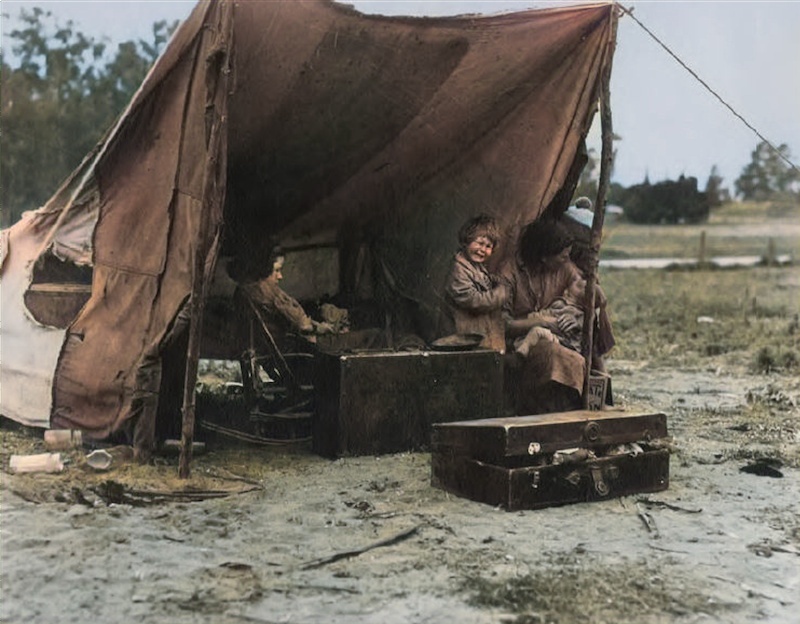 A colourised portrait of a mother and her children beside a tent